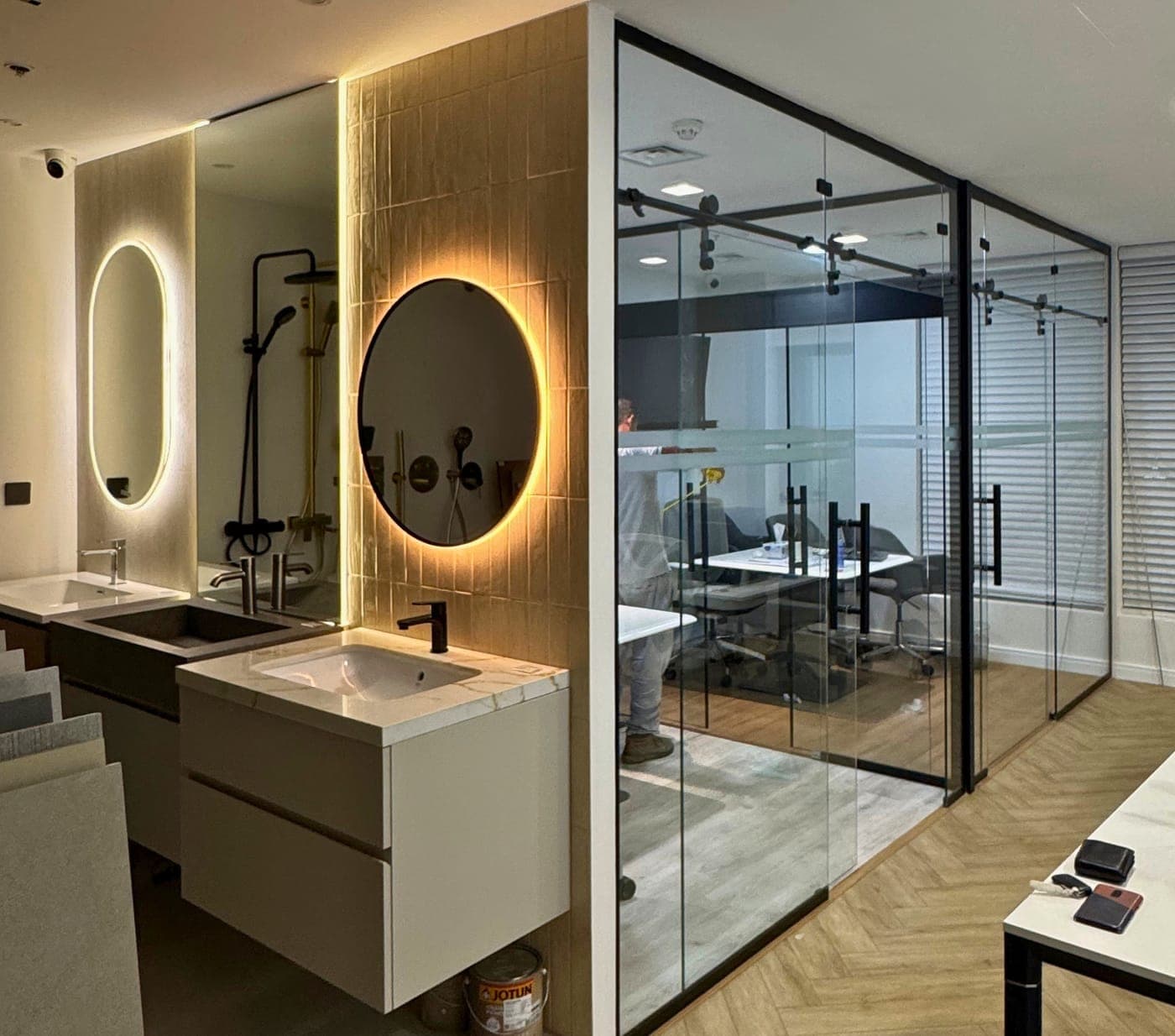 Glass partition walls with black sliding door hardware beside a washroom vanity