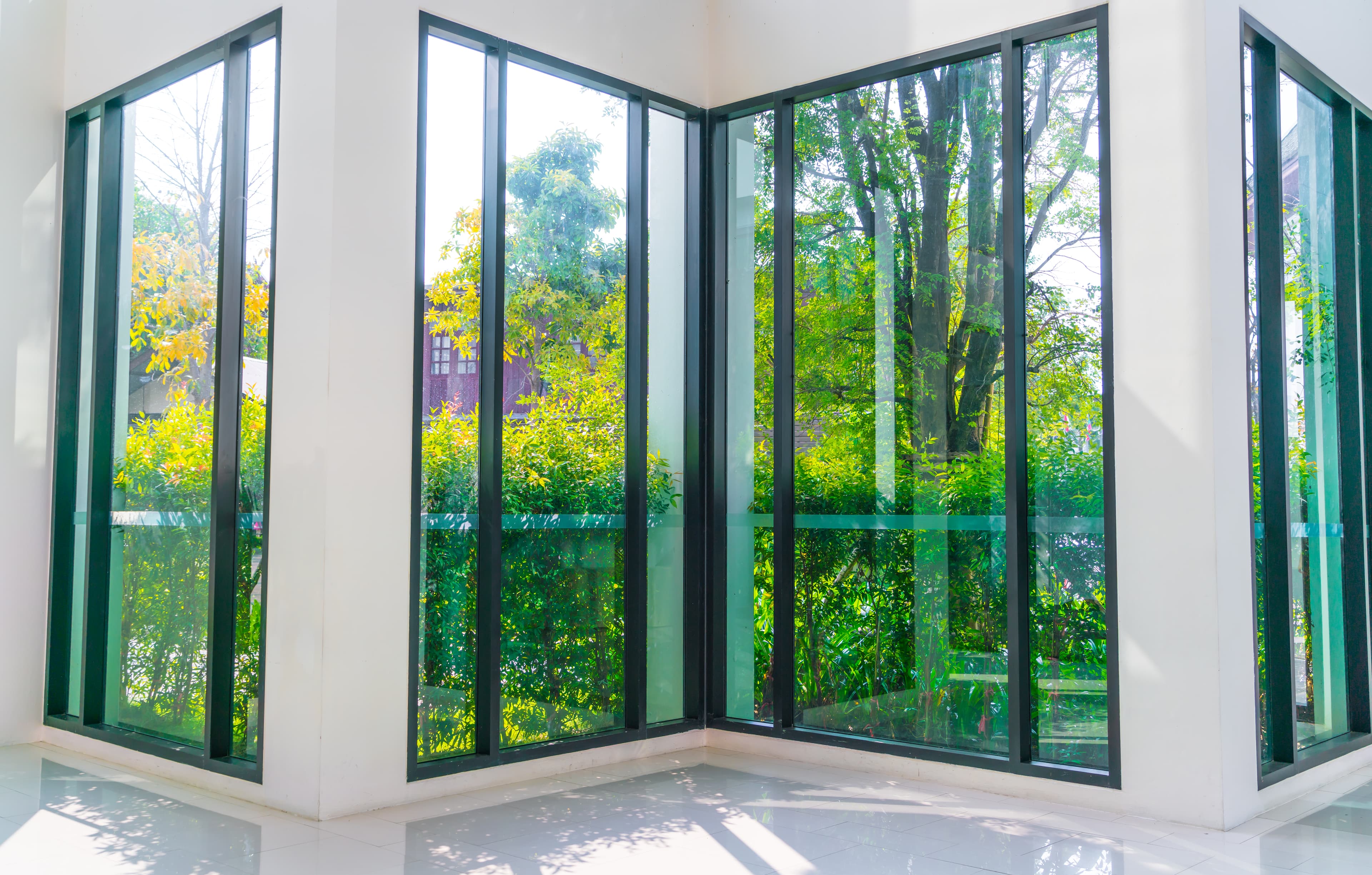 Floor-to-ceiling glass window overlooking a green garden