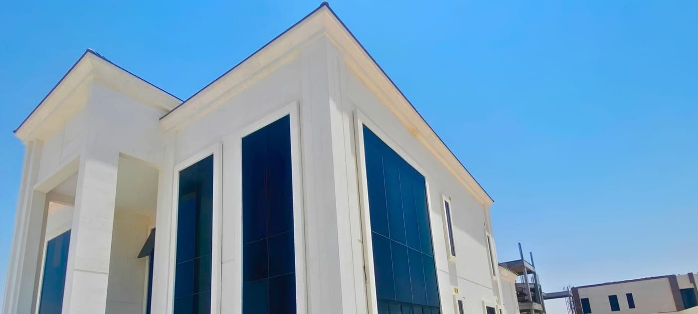 Side of the same villa with full-height tinted windows under a gabled roof